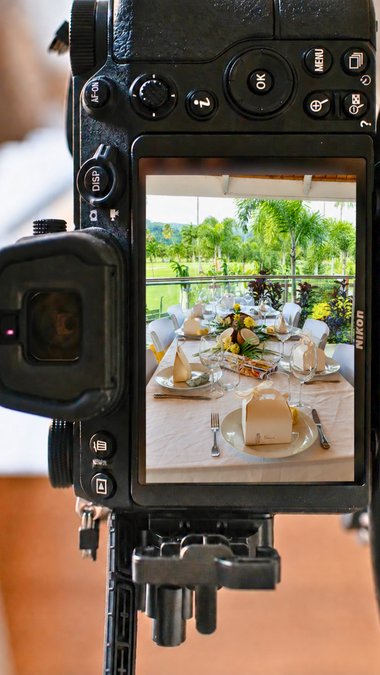 L’écran d’un appareil photo Nikon qui affiche une table dressée pour un événement, au bord d’une terrasse