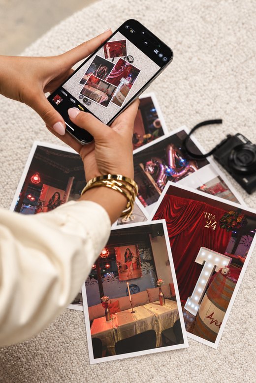 Dans les coulisses : un téléphone qui photographie des tirages d’événements, avec un appareil photo à côté