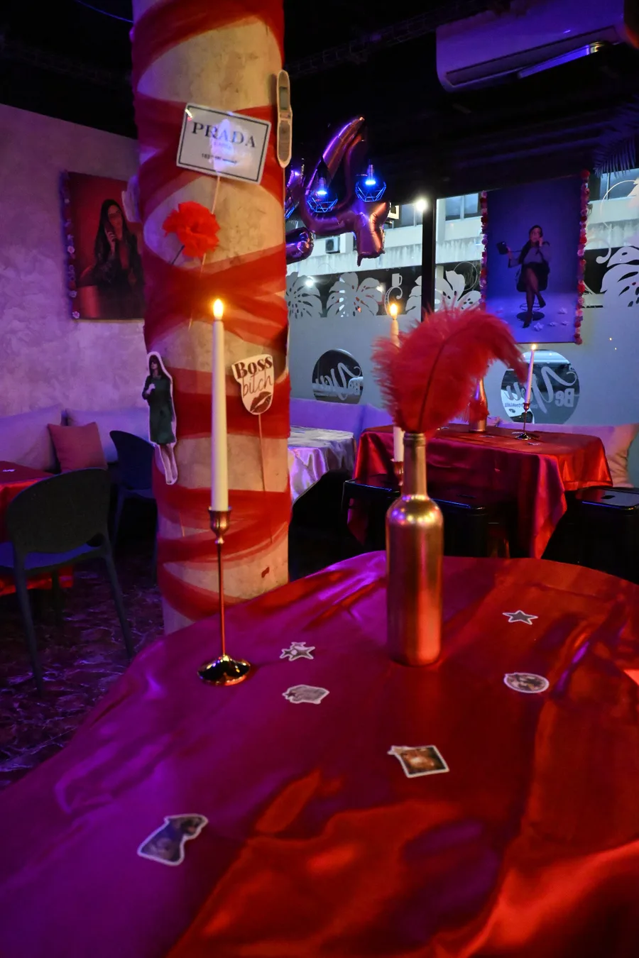 Décoration de soirée rouge et or : colonne drapée de tulle, bougies et plume