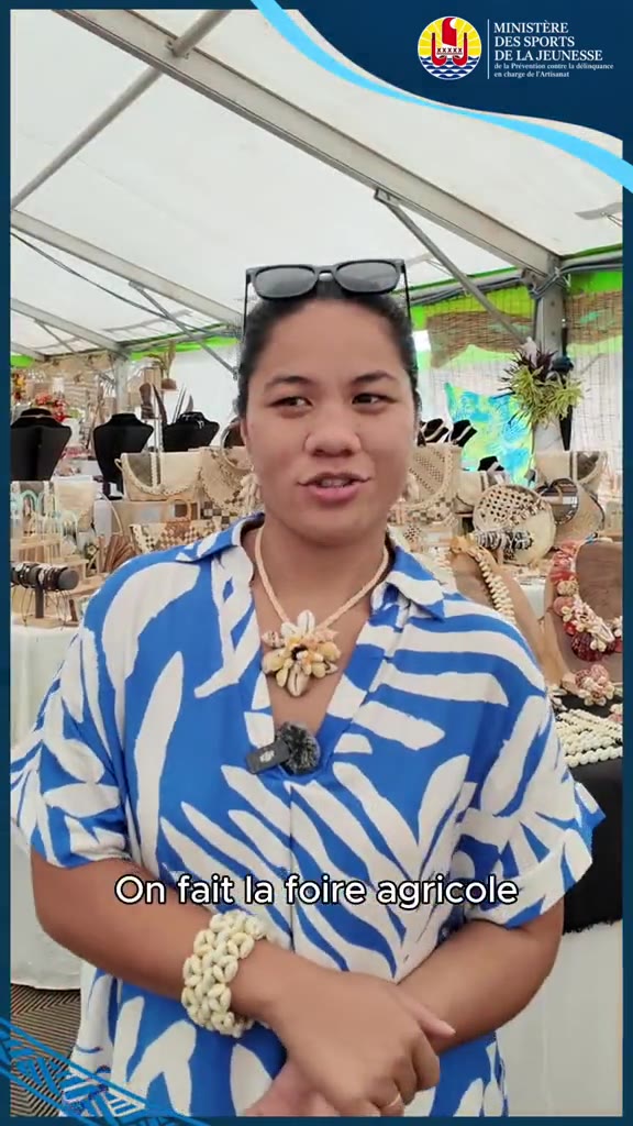 Aperçu de la vidéo « Foire agricole » : une femme en chemise bleue et blanche devant un stand d’artisanat