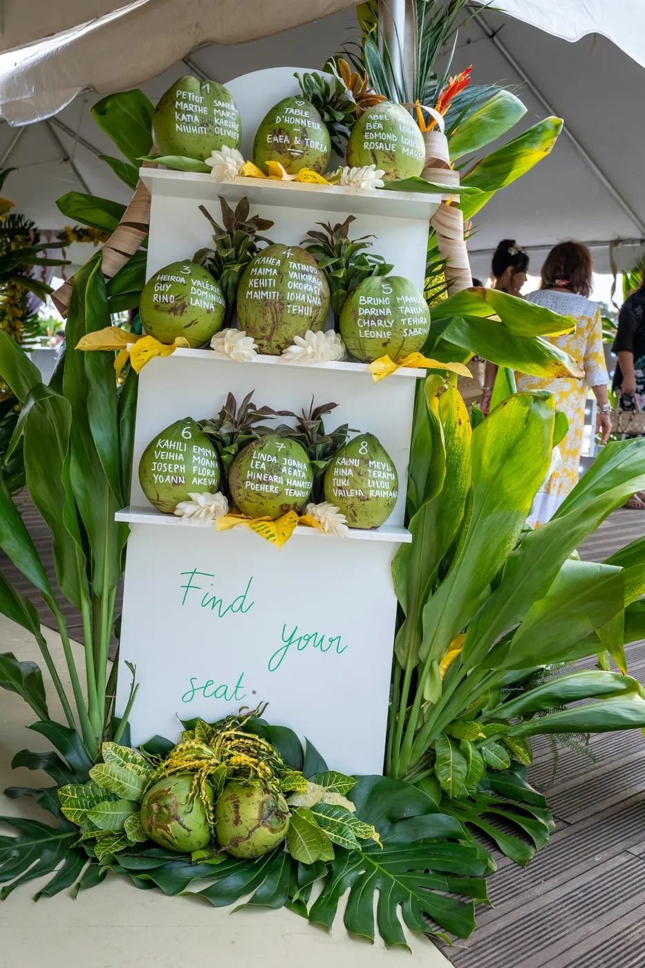 Plan de table sur noix de coco, avec les noms des invités écrits à la main