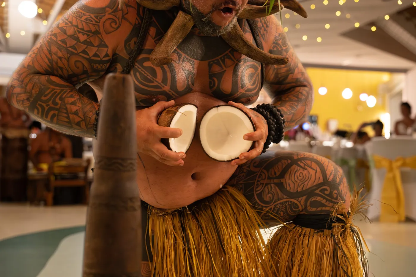 Danseur tatoué ouvrant une noix de coco